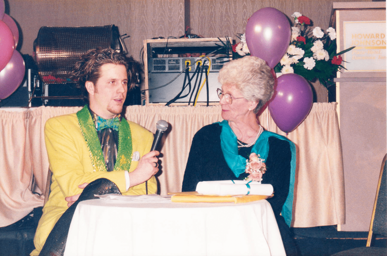 Two people at a table, one interviews the other with a microphone